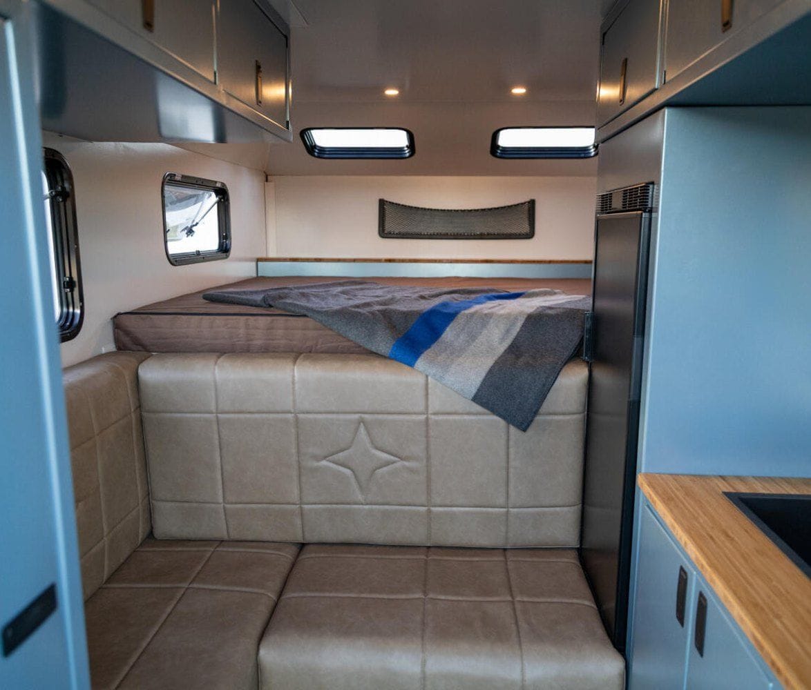 alaskan-hs-640-composite-pickup-camper-09-interior-overview-bed-and-seating-1174x1000.jpg | Image